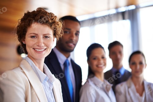 Preview: Portrait of an attractive businesswoman with her colleagues standing behind her