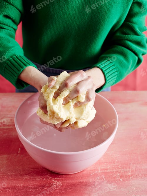 Preview: Hands kneading dough in a pink bowl