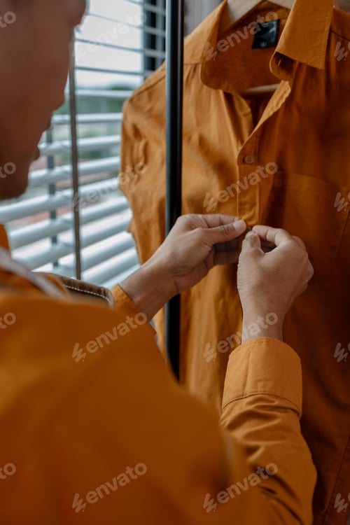 Preview: a designer is working in his studio, checking all clothes before sent to shop, talented designer is