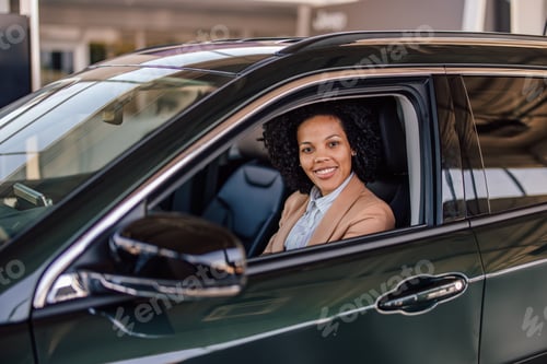 Visualização: Retrato de mulher afro-americana, sentada em seu carro novo.