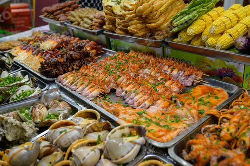 Preview: From above of assorted fresh seafood and boiled corns placed in containers on stall in local bazaar