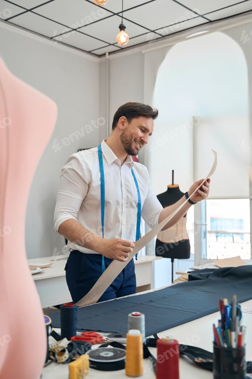 Preview: Man couturier examines the pattern of the sewing workshop