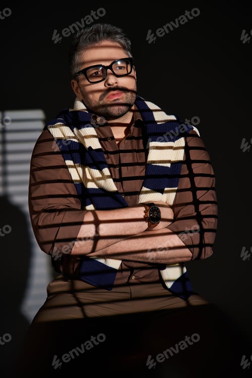 Preview: Stylish man in elegant outfit poses confidently in modern studio lighting