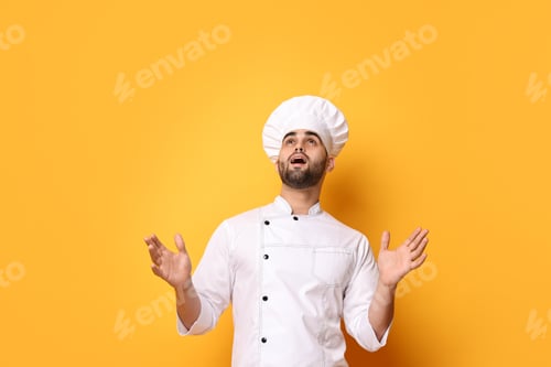 Preview: Surprised chef in uniform on yellow background