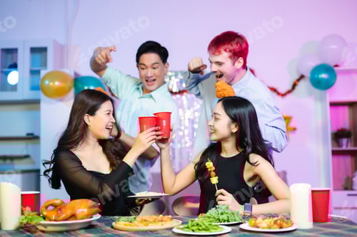 Visualização: Um momento de festa divertido, onde jovens amigos brindam com copos vermelhos e riem enquanto um brinca com batatas fritas