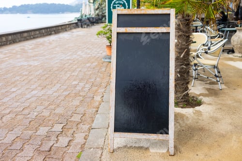 Preview: Wooden frame chalkboard stands on summer pavement. Copy space