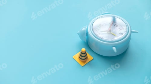 Preview: Fixing, maintenance and under construction concept. Alarm clock with traffic cones.