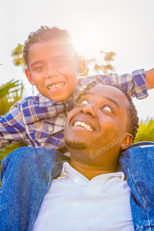 Preview: Mixed Race Son and African American Father Playing Piggyback Outdoors Together.