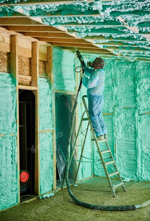 Preview: Worker spraying polyurethane foam for insulating wooden frame house.