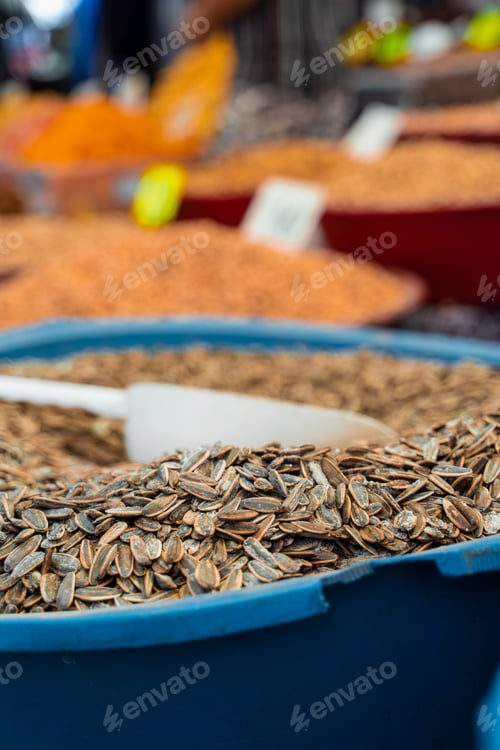 Preview: Roasted white sunflower seeds sold in market with spice background