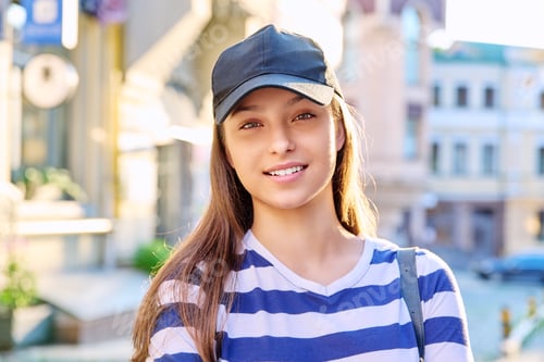 Preview: Outdoor portrait of teenage girl in black cap, city street background