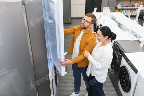 Preview: family couple buying domestic refrigerator in supermarket