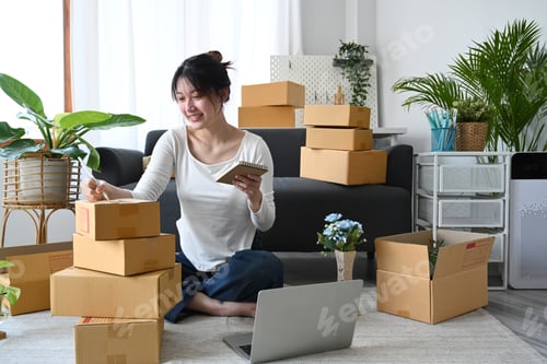 Preview: Start up business entrepreneur sitting in modern home office and preparing parcel for delivery.