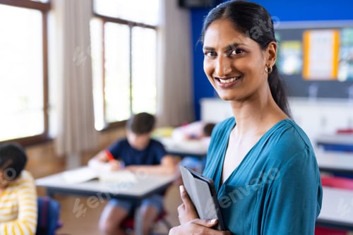 Visualização: Professora indiana sorridente segurando tablet na sala de aula com alunos na escola, espaço de cópia