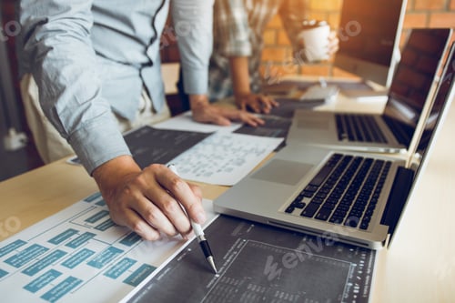 Preview: Software developer is pointing to the paper working and analyzing together the code written