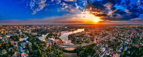 Preview: Aerial panorama view of small european city placed on river banks at summer sunny day with clouds