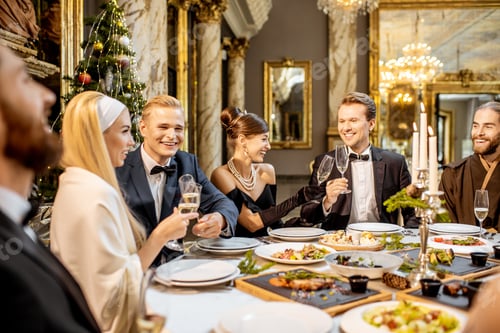 Vista previa: Personas elegantemente vestidas que tienen una cena festiva en el interior