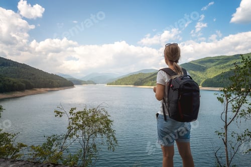 Preview: Woman enjoying view of beautiful mountain lake