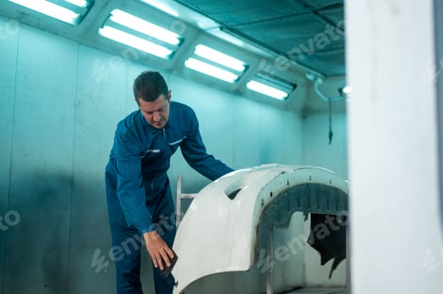 Preview: Caucasian man is cleaning car parts before spraying color