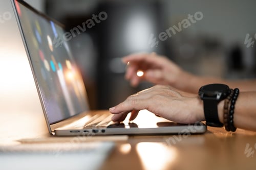 Preview: A close-up shot of hands typing on a laptop keyboard in warm light, ideal for focused work