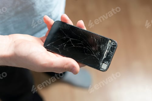 Preview: the person holding crashed smartphone, broken screen of mobile phone
