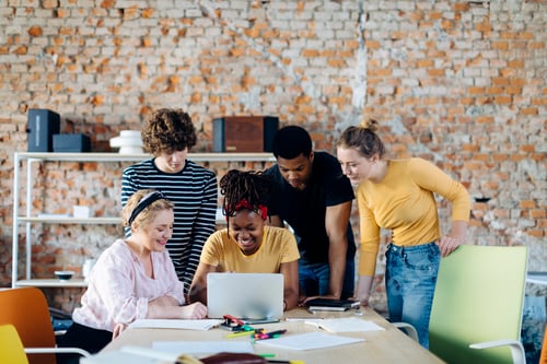 Preview: Young people working together at table using laptop