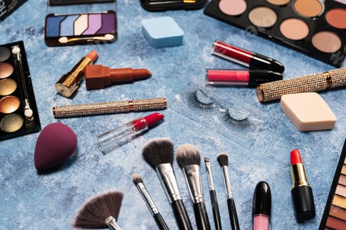 Preview: makeup brushes, decorative cosmetics, false eyelashes on a blue background. the view from the top
