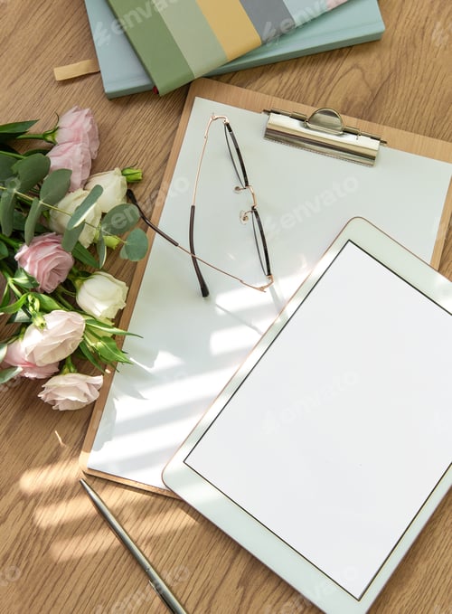 Preview: Stationery workspace with a blank tablet, notebook, and flowers on a wooden table
