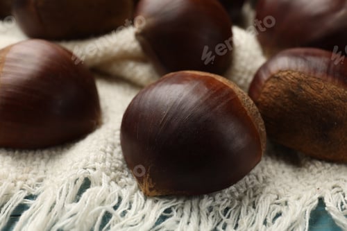 Preview: Roasted edible sweet chestnuts on table, closeup