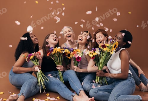 Preview: Group of diverse women with bouquets having fun under falling petals