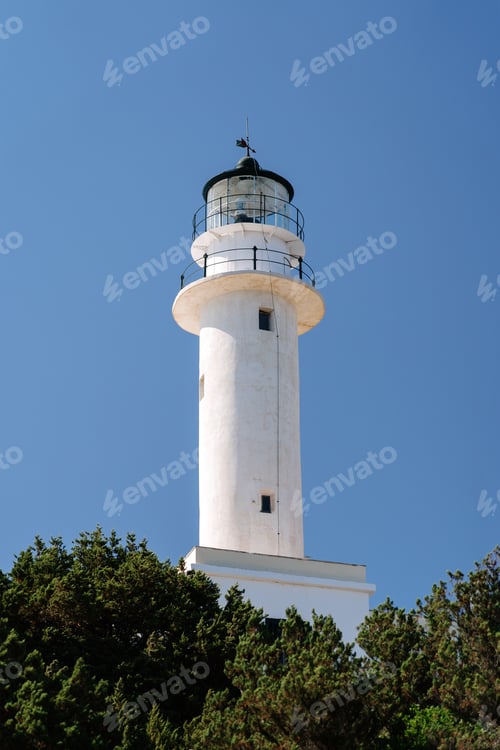 Preview: White lighthouse tower against a clear blue sky