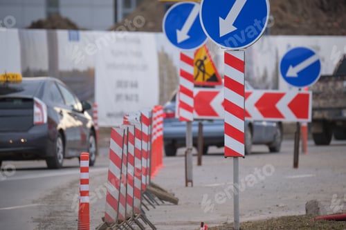 Preview: Roadworks warning traffic signs of construction work on city street and slowly moving cars