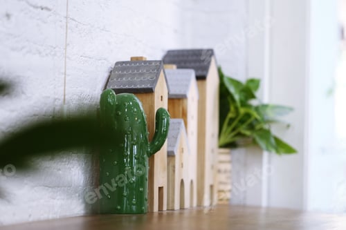 Preview: Wooden houses and ceramic cactus on desk