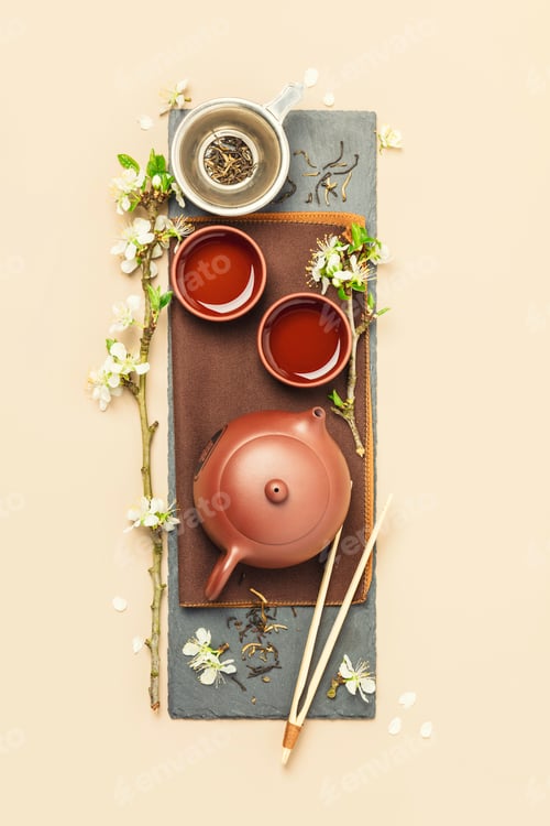Preview: Asian Tea set on stone slate board, ceramic teapot, cups, dried tea and spring branches