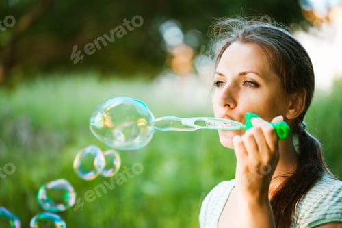 Preview: Girl blowing soap bubbles in the park