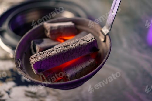 Preview: close-up of hot coals that are put on the grill in a Korean restaurant before cooking food concept