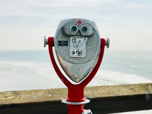 Vorschau: Fernglas-Sucher am Strand mit Blick auf den Ozean mit Brandung im Hintergrund