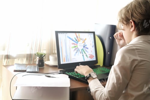 Preview: A young businessman sits in front of his laptop and studying the stock market