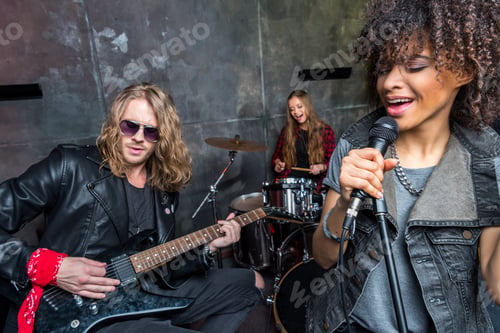 Preview: young rock band rehearsing in musical studio, band on stage concept