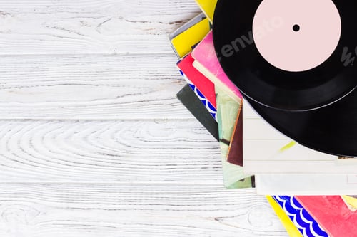 Preview: Black vinyl records on the wooden table, selective focus with copy space. Top view