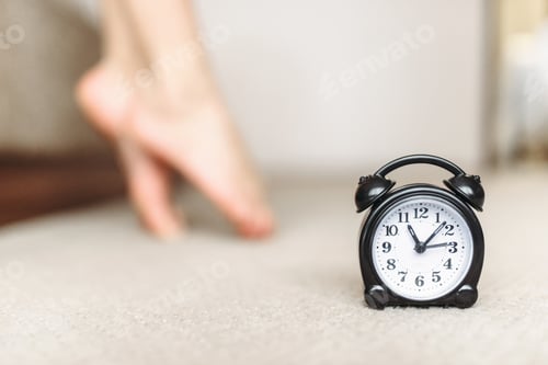 Preview: Alarm clock, female legs, waking up concept