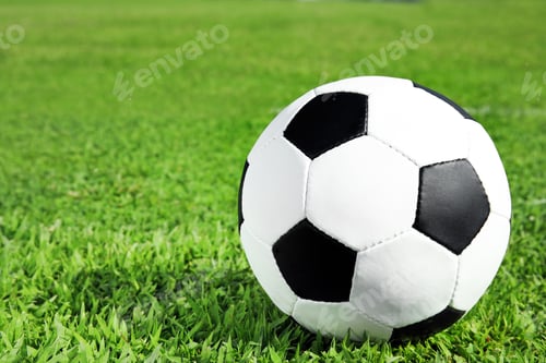 Preview: Soccer ball on fresh green football field grass. Space for text