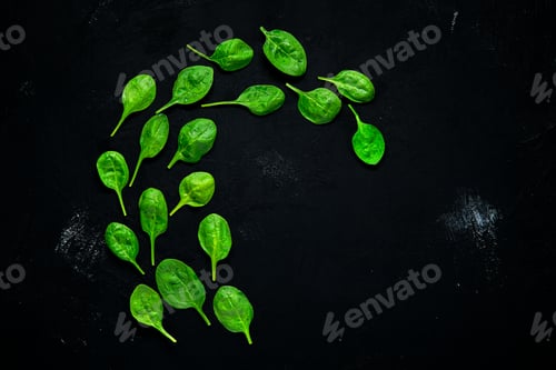 Preview: Fresh green baby spinach leaves on abstract black background