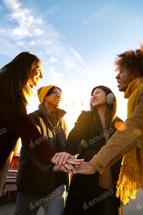 Preview: Multiracial friends stacking hands together in a circle as symbol of community, friendship. Vertical