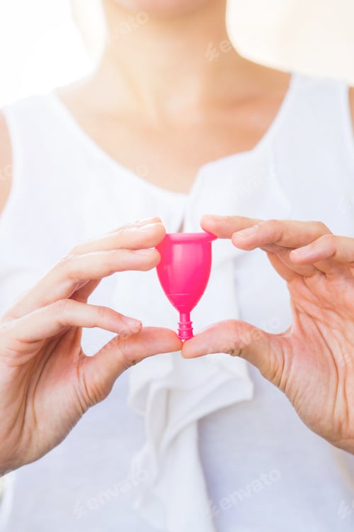 Preview: Woman holding a menstrual cup in hands