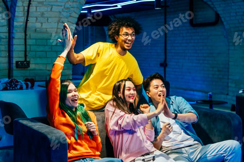 Preview: Multiethnic group of young friends playing videogames at home