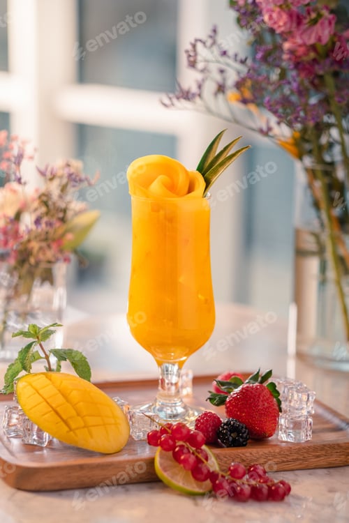 Preview: Glass of refreshing fruit cocktail with a bowl of freshly picked flowers