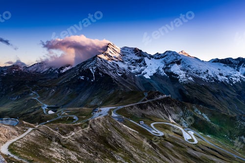 Preview: Dramatic Sunset at Snowy Mountains Peaks and High Alpine Road