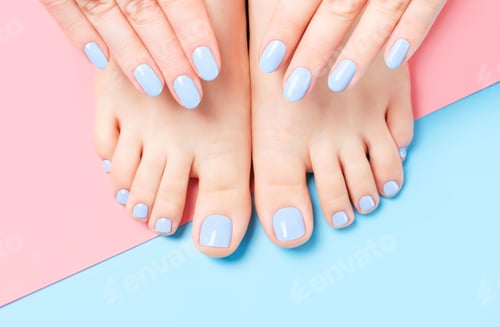 Preview: Female hands and feet with manicure and pedicure on a blue and pink background top view close-up.
