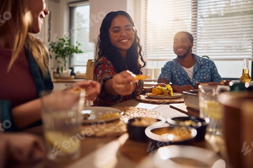 Preview: Happy Indian woman and her friends enjoying in Mexican food at dining table.